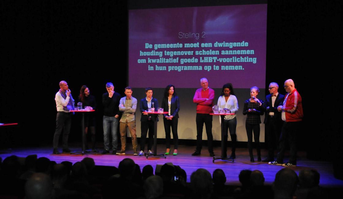 De raadsleden met elkaar in debat. V.l.n.r.: Nico van Scheijndel (50Plus), Marianne Bernard (PvdD), Co Engberts (PvdA), Jimmy Smet (GroenLinks), presentatrice Caroline van Haften, Nadia Arsieni (D66), Bart-Joost van Rij (Leefbaar Rotterdam), Ramona Cairo (SP), Christine Zandberg (CDA), presentator Edwin Westenberg en Pascal Lansink-Bastemeijer (VVD).